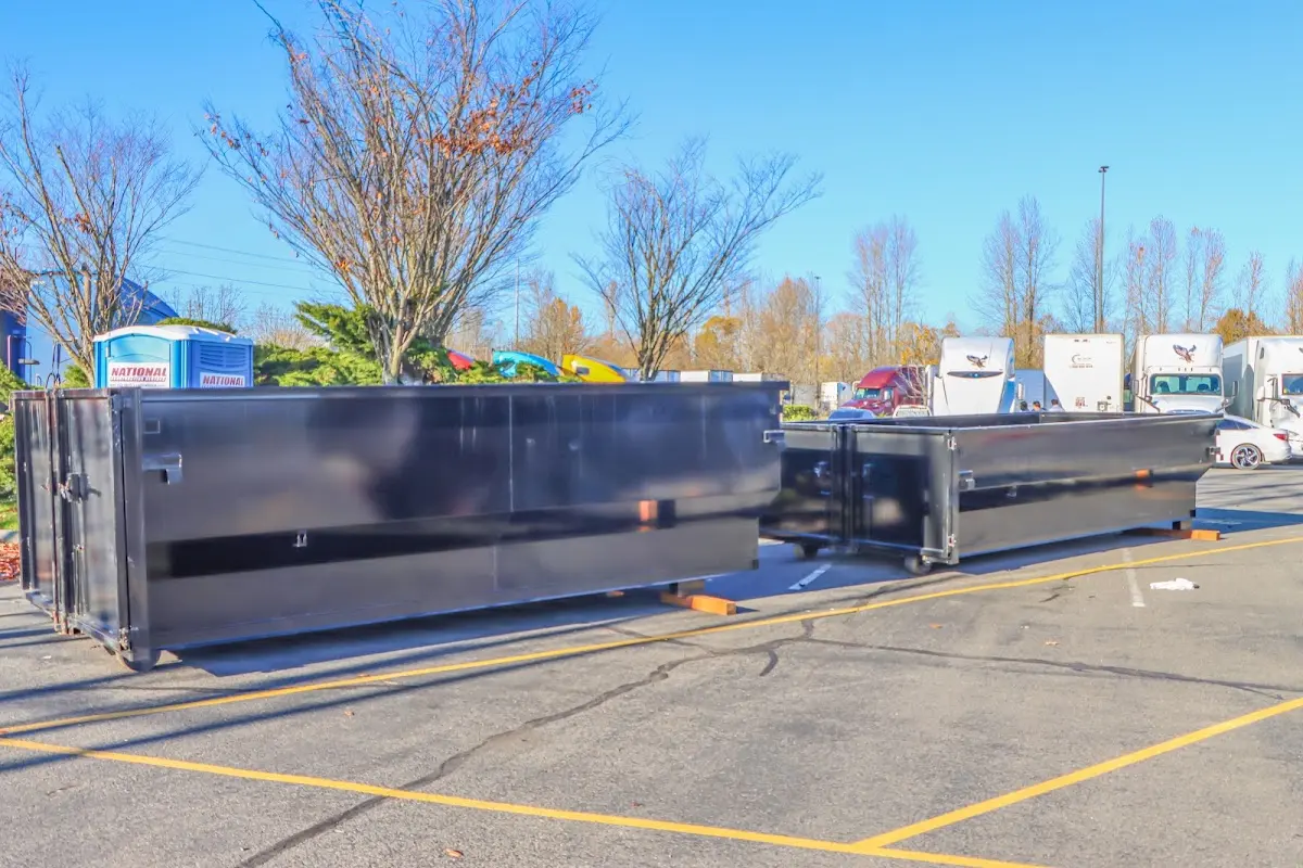Professional dumpster rental service with roll-off container on residential driveway in Badger